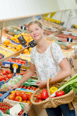 Lady in greengrocers holding a wicker basket