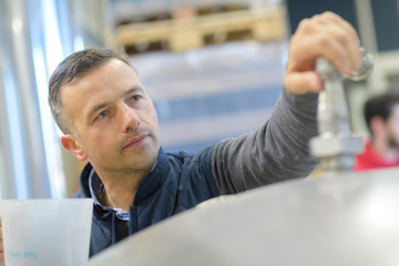 male customer looking at modern faucets in hypermarket