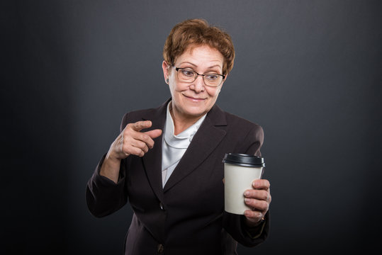 Business senior lady pointing takeaway coffee and smiling