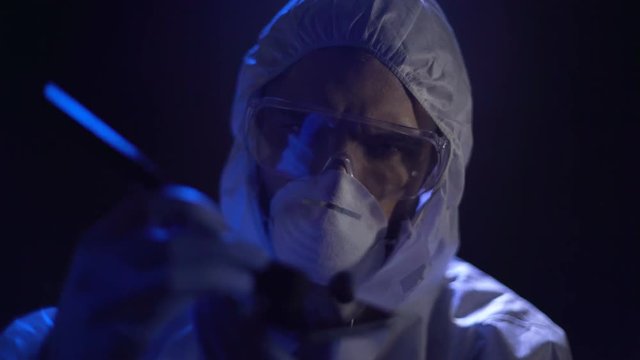 Forensic scientist discovering and collecting latent fingerprints from cellphone
