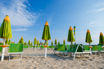 Empty beach with a lot of sunbeds and umbrellas in the morning. Emilia Romagna, Italy.