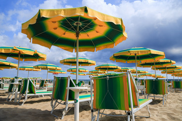 Beautiful beach with colorful sun umbrellas and blue sea in the Adriatic coast of Emilia-Romagna.
