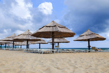 Straw umbrellas on a beautiful tropical beach background.