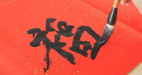 Writing chinese calligraphy with word meaning luck for lunar new year