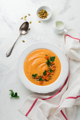 Homemade pumpkin soup in white ceramic dish on an old concrete or stone background. Selective focus.  Top view. Copy space.