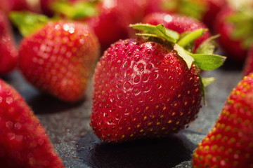 strawberries on stone background, delicious first class organic fruit as a concept of summer vitamins