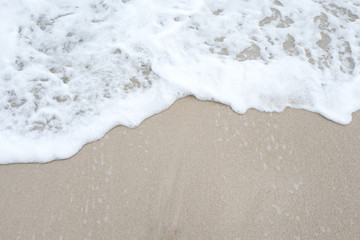 Top view image of waves on tropical white beach with sand