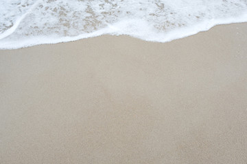 Top view image of waves on tropical white beach with sand