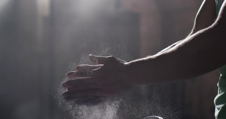 Man with chalk on his hands clapping