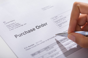 Obraz premium Person Hand Filling A Purchase Order Form