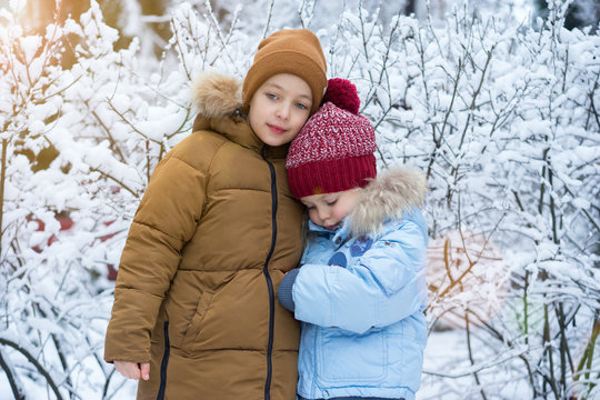 Portrait of two boys in a knitted hat in winter forest
