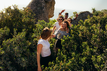 Group of friends walking through a mountain trail