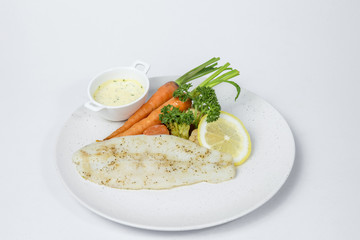 Fish fillet steak served with cooked vegetable and cream sauce