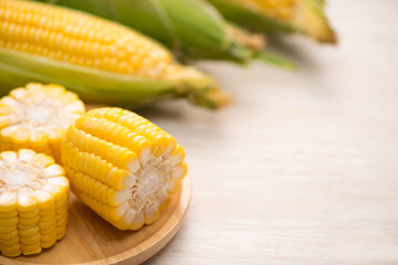 Sweet corns. Fresh corn on cobs on wooden table.