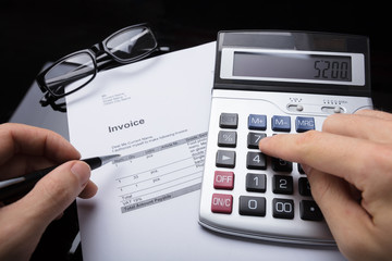 Businessperson Calculating Invoice