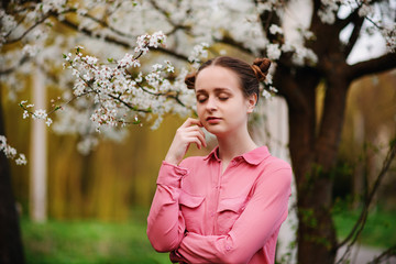 Sensuality. Happy beautiful young woman relaxing in blossom park