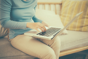 Naklejka premium Happy casual beautiful asian young woman working on a laptop at home.