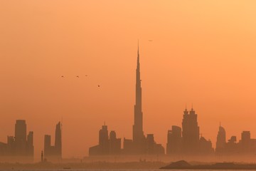 Naklejka premium DUBAI SKYLINE UNDER SUNRISE, TWO LANDMARKS, BURJ AL ARAB AND BURJ KHALIFA, THE TALLEST BUILDING IN THE WORLD