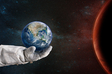 Earth in the hand of astronaut. Earth Day concept. Elements of this image furnished by NASA.