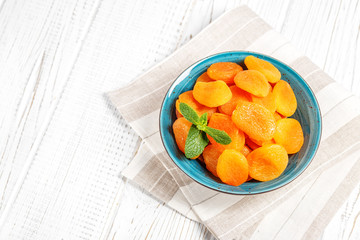 Dried apricots with mint in a bowl. Top view. The concept is healthy food, diet, vegetarianism.