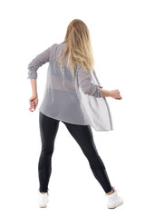 Back view of elegant feminine blonde woman dancing wearing striped shirt and leggings. Full body length portrait isolated on white studio background. 