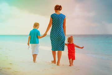 mother and two kids walking on beach