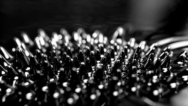 Ferrofluid under the influence of a magnetic field.  Black liquid surface. Abstract object.

