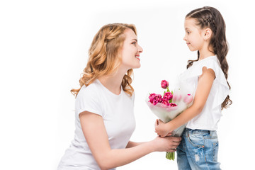 side view of happy mother and little daughter with bouquet of flowers isolated on white, mothers day concept