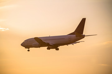 Fototapeta na wymiar Airplane landing at sunset