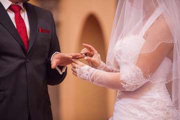 La mari&eacute;e passe la bague au doigt du mari&eacute;