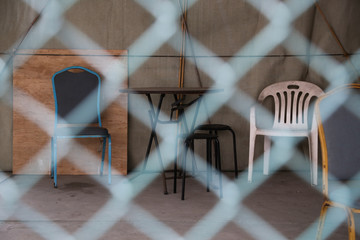 Fototapeta na wymiar Chair and table beyond barbed wire in HongKong