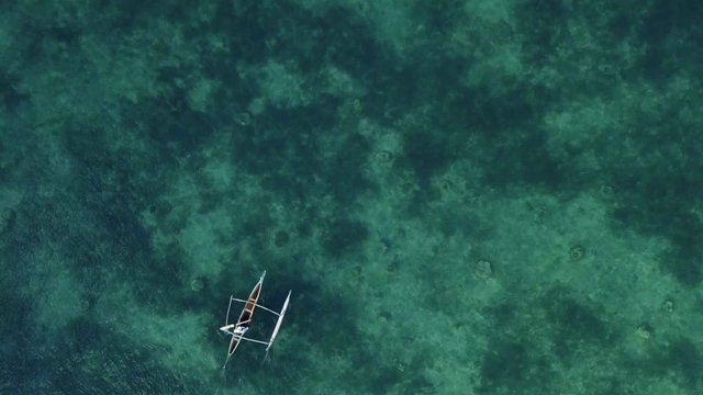 Birds eye view of fisherman on pirogue boat on sea