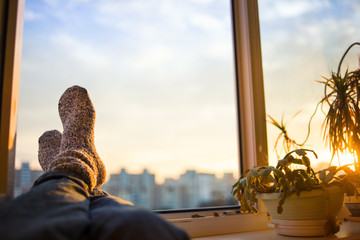 Men's feet in socks on relaxation window - obrazy, fototapety, plakaty