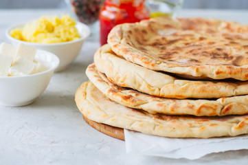 Mashed potato and sheep cheese filling flatbread on a white stone background.