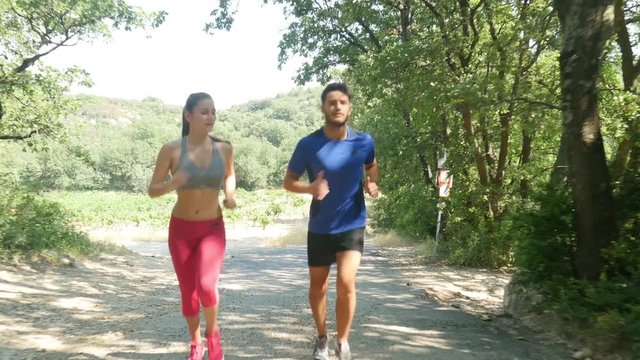 beautiful young couple running sport fitness exercising together outdoor countryside forest