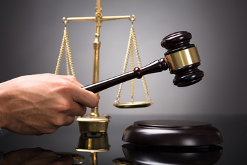 Judge Striking Gavel On Sounding Block