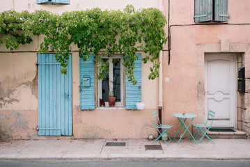 Naklejka premium Colourful house wall facade, orange damages cracked walls, blue door and shutters, Provence village, south France