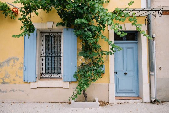 Colourful house wall facade, yellow wall and light blue doors and shutters, Provence village, south France