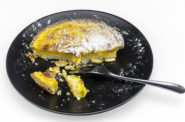Lemon cake on black dish on white background