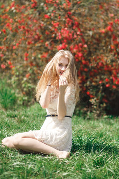 Beautiful young woman enjoying sunny day in park during blossom season on a nice spring day.