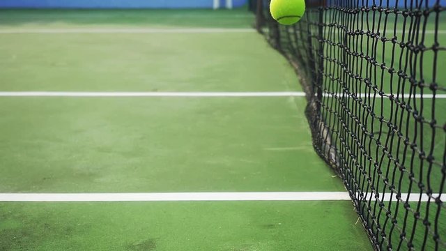 Tennis ball falling on a tennis court near the mesh. slow motion. 1920x1080. hd
