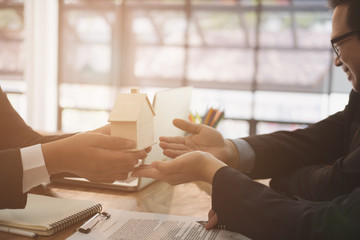 man applying for mortgage loan with bank employee. client signing contract document with realtor at real estate agency. property, finance & banking concept