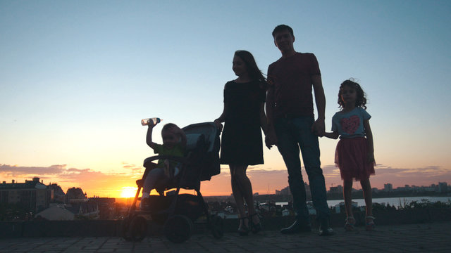 Family at sunset - father, mother, daughter and little son - silhouette