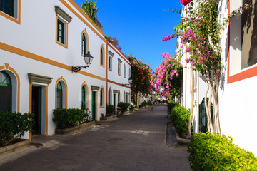 Fototapeta na wymiar Wonderful alley with colorful flowers, doors and windows in Puerto De Mogan on Gran Canaria island.