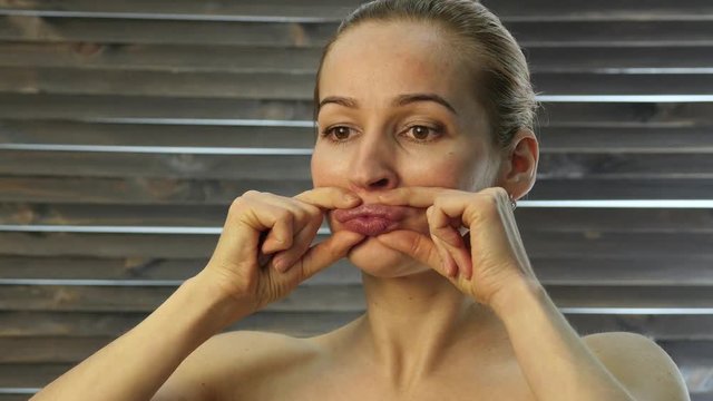 woman performs anti-aging exercises. gymnastics for anti sagging face skin