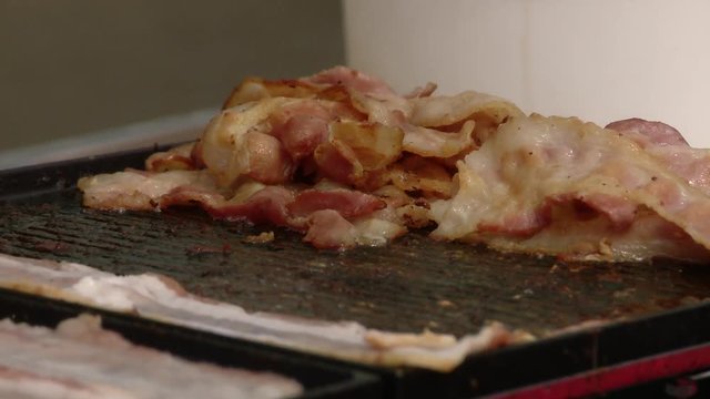 Cooking delicious bacon at food and BBQ festival.