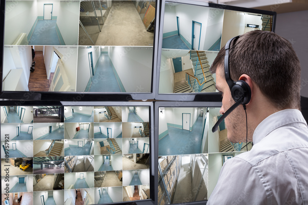 Poster Operator Looking At Multiple Camera Footage On Computer