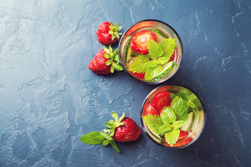 Detox water with strawberry and cucumber in a glass on dark background. Top view. Copyspace.