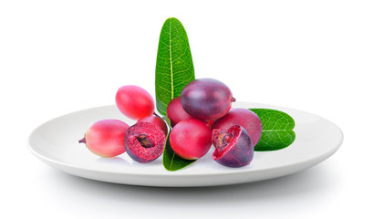 bengal-currants, carandas-plum, in a plate isolated on a white background