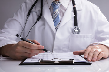 Close-up Of A Doctor Analyzing Report